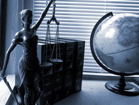 Justice scale, books and globe map